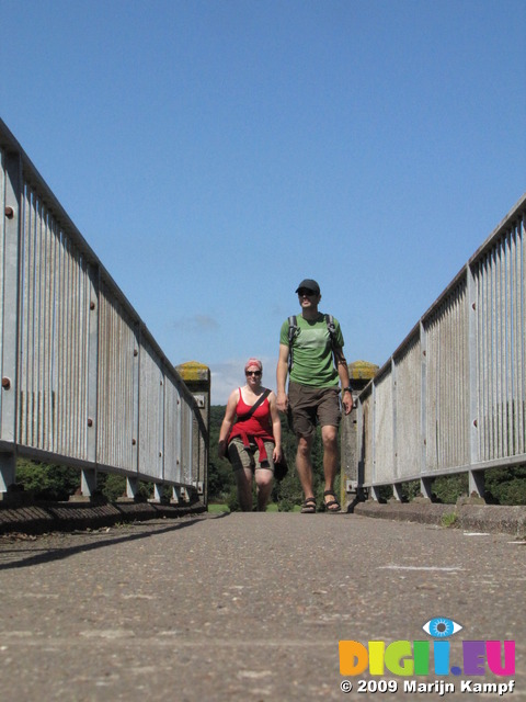 SX07986 Kristina and Wouko walking over footbridge near Ogmore Castle